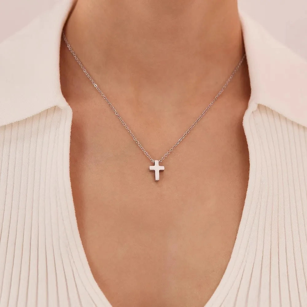 Little Faith stainless steel tiny cross necklace in silver-tone, shown worn