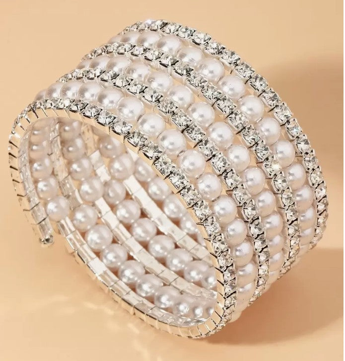 “7-tier silver-tone bracelet with rhinestones and faux pearls”

“Elegant silver bangle with layered pearl and rhinestone design”

“Silver stacked bracelet for weddings and spiritual occasions”

“silver rhinestone and faux pearl bangle bracelet”